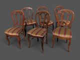 quatre chaises avec une assise rembourrée à rayures et un piètement en bois