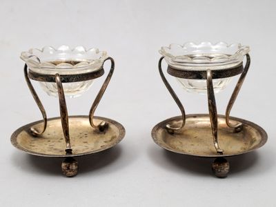 paire de bougeoirs plaqués argent avec des supports en verre sur des socles