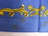a blue scarf with a gold design on it
