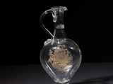 a clear glass vase with a gold decoration on it