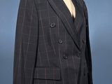 a suit on a mannequin stand with a blue background