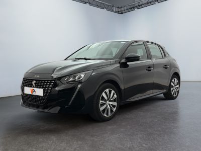 Une voiture grise est garée dans une pièce blanche au sol noir.