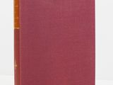 a red book sitting on top of a table next to a white wall