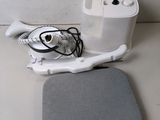 un appareil blanc et un coussin gris posés sur une table