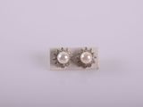 a pair of pearl and diamond earrings on a white background