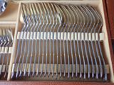 silverware in a wooden box on a table with a spoon and fork