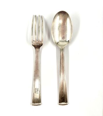 two silver spoons and a fork on a white surface