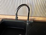 a black sink with a black faucet and a black faucet
