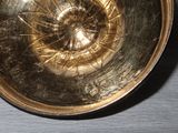 a metal bowl with a hole in it sitting on a table
