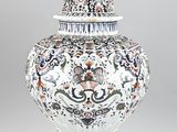 un oiseau perché sur un vase posé sur une table
