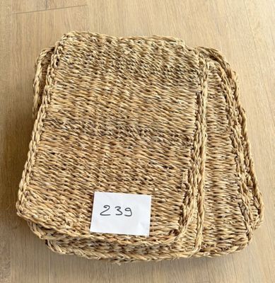 deux sets de table en osier, avec une étiquette de prix, posés sur une table