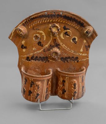 an image of a brown vase with two cups on it