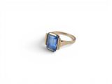 a close up of a gold ring with a blue stone