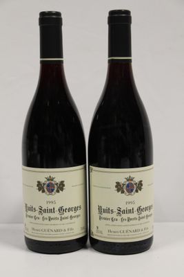 two bottles of red wine sitting next to each other on a table