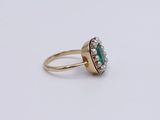 a close up of a gold ring with a green stone