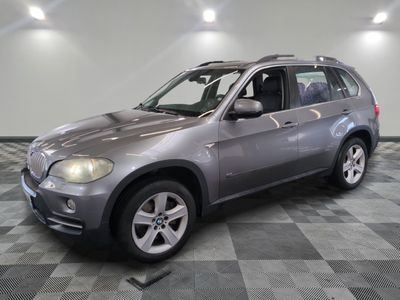 une photo d'un SUV BMW argenté garé dans un showroom