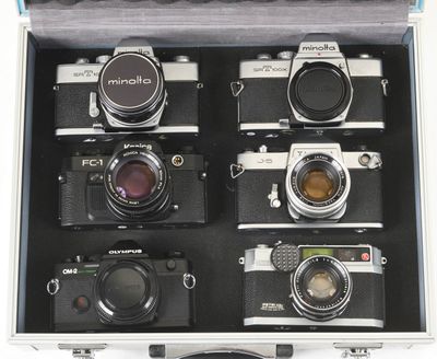six cameras in a case with a lens on top