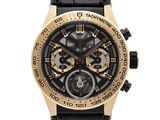 La montre est noire et dorée, avec un bracelet en cuir noir.