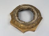 a gold colored object on a white surface