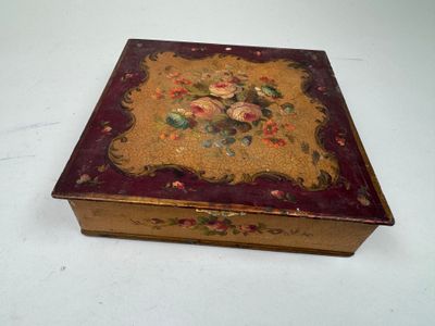 une petite boîte décorée de fleurs, posée sur une table
