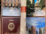 several books are sitting on a table in front of a building