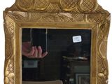 a mirror with a gold frame and a hand in the mirror