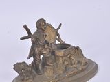 a bronze figurine of a man and a dog on a rock