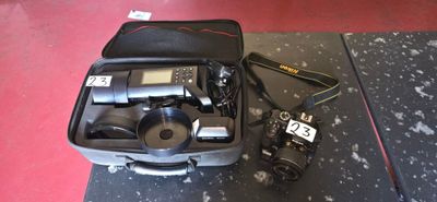 a suitcase with a camera and other items in it on the floor