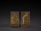 a pair of bronze bookends depicting a woman and a man