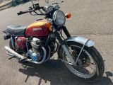 une moto rouge et jaune garée sur le bord de la route