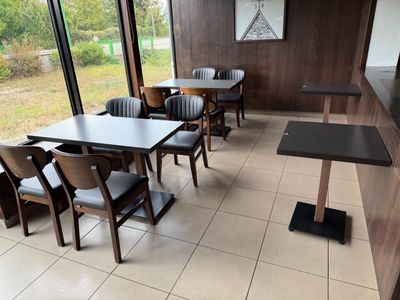 tables and chairs in a restaurant with a view of the outside