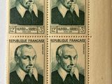 four stamps with a picture of a man in a suit and tie on them