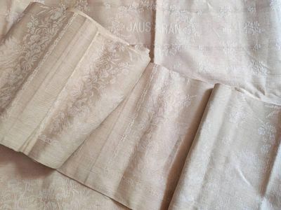 Plusieurs morceaux de tissu sont disposés sur un lit dans une chambre.