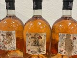 four bottles of alcohol sitting on a table with a red cloth