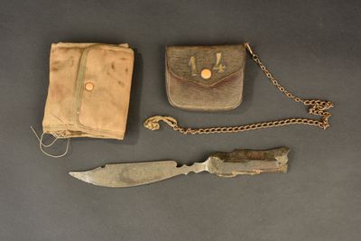 a knife, wallet, and chain on a table