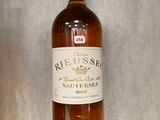 une bouteille de vin posée sur une étagère en verre dans une pièce