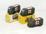 Trois véhicules militaires miniatures sont posés dans une boîte sur une surface blanche