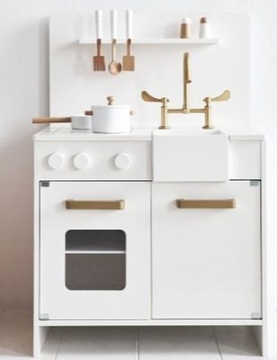 a white kitchen with a white stove and white cabinets