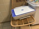 a printer sitting on a wicker chair next to a washing machine