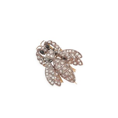a close up of a gold and diamond broochle on a white background