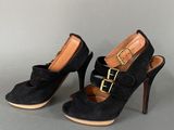 black sued high heel shoes with gold buckles on the toes