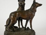 statue en bronze représentant deux chiens debout sur un rocher, sur fond blanc