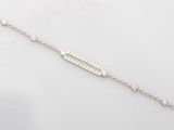 a close up of a silver bracelet with diamonds on a white background