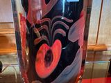 un vase en verre orné d'un motif rouge et noir
