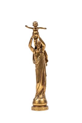 une statue en or représentant une femme tenant un oiseau sur son épaule
