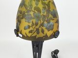 lamp with a yellow shade with blue flowers on it and a cord plugged into the base