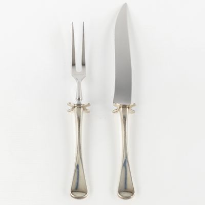 deux fourchettes et un couteau sur une surface blanche