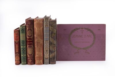 plusieurs vieux livres sont empilés sur une surface blanche