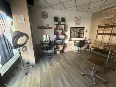 une photo d'un salon avec de nombreux fauteuils et une table