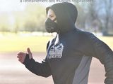 a man in a black hoodie running on a race track